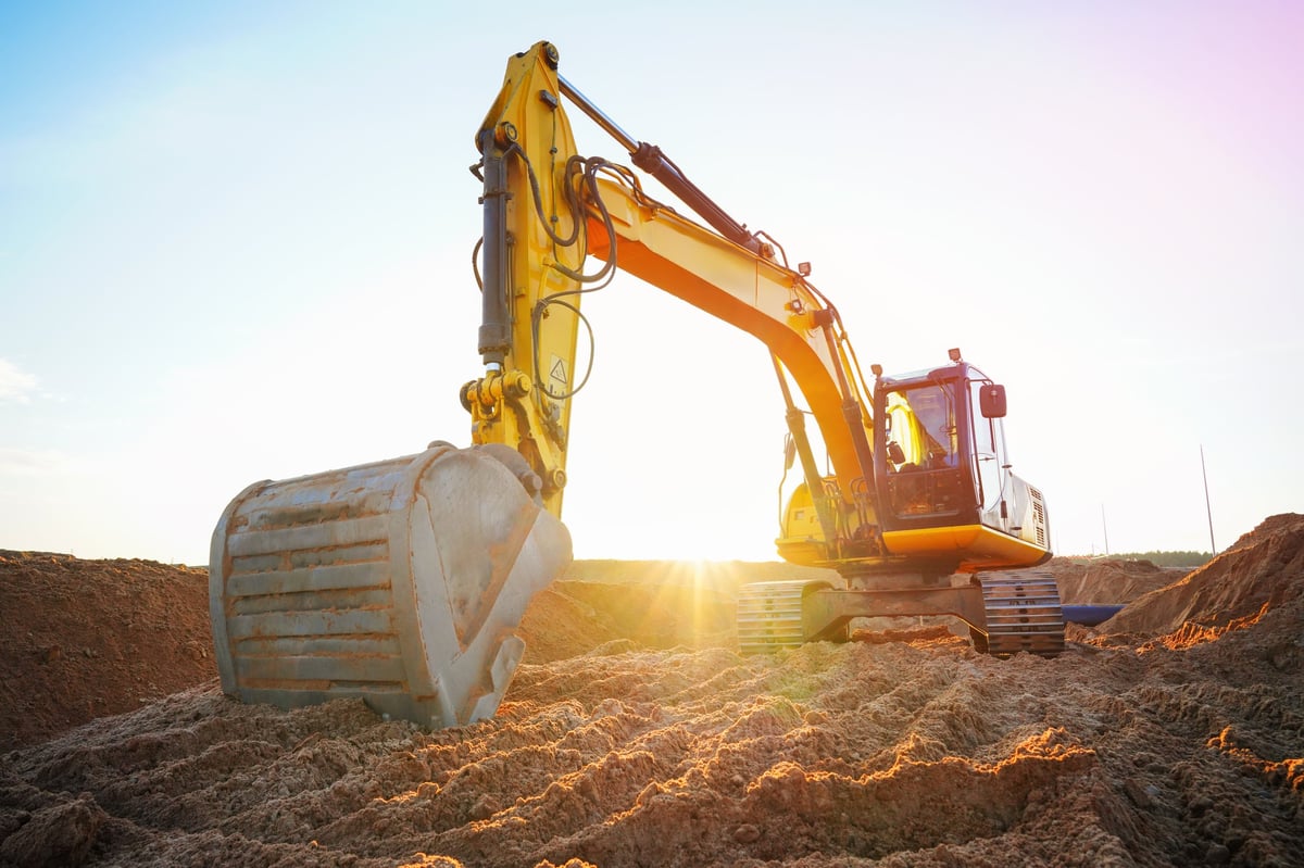 Excavator at construction site at golden hour sunset